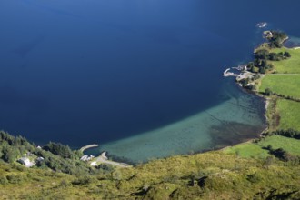 Coastal landscape with clear blue water and green meadows, houses, Otroya or Otrøya island, Møre og