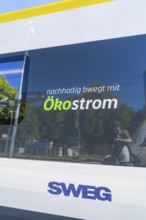 Train with sustainable ecological advertising and reflections on the window, battery Electric train