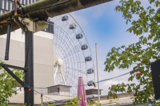 Ferris wheel in an urban environment with plants and hanging lights, Werksviertel Munich, Munich,
