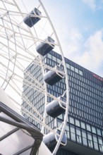 Close-up of a Ferris wheel next to a modern glass building, Werksviertel Munich, Munich, Germany