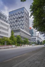 Modern office building along a street with trees and transport infrastructure, Munich, Germany