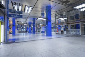 Empty underground building with reflections and blue poles, Münchner Freiheit, Munich, Germany