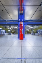 Modern underground station with blue and red elements and SOS station in Munich, Münchner Freiheit,