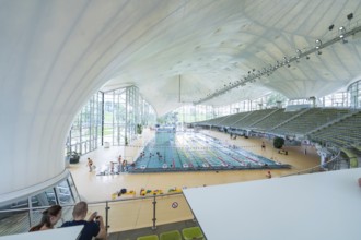 View from above of a modern swimming pool with grandstands and lots of glass, Olympiabad, Munich,