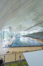 Modern swimming pool with glass façade and seating in a bright atmosphere, Olympiabad, Munich,