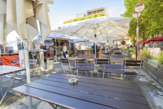 Empty outdoor café with tables and chairs under parasols, sunny and inviting, Sindelfingen,