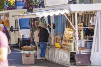 An open-air market stall offers fresh produce, with customers interacting, Sindelfingen, Böblingen