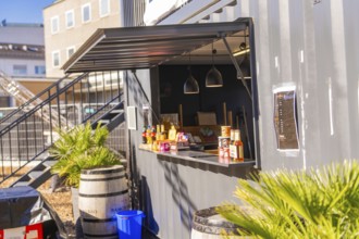 Close-up view of a snack bar in a container with barrels and plants, open-air cinema Sindelfingen,
