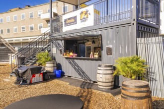 A snack container with barrels and plants outside in the sunshine, open air cinema Sindelfingen,