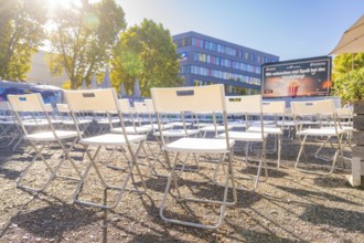 Rows of chairs outdoors under an umbrella in bright sunshine, open air cinema Sindelfingen,