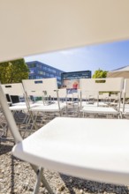 Rows of white chairs in front of an outdoor screen on a sunny day, open air cinema Sindelfingen,