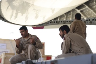 Members of the Qatari Air Force unload humanitarian aid supplies from a transport aircraft at