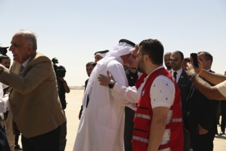 Officials from the Qatari and Syrian Red Crescents receive a Qatari airlift of aid to help the