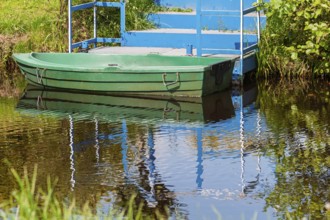 Green boat anchored in front of a blue staircase, Lower Saxony, Germany