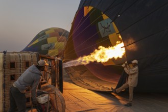 In order to get ready for the take-off, the pilot inflates the balloon with hot air by activating