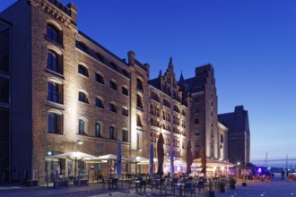 Night shot, outdoor seating, sunshades, restaurant, illuminated, romantic scenery behind, building,