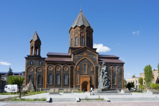 Large church with striking architecture and sculpture in the foreground, clear blue sky, Church of