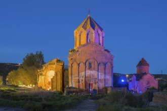 Illuminated church ruins in the evening light, surrounded by natural landscape, Marmashen Monastery