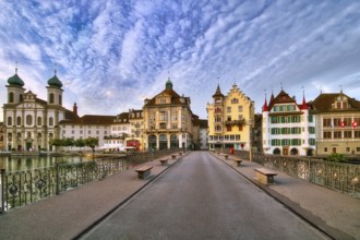 View from the Reuss bridge onto the old town of Lucerne with Jesuit church, decorative cloudy