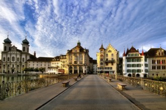 View of Lucerne's old town with Jesuit church from the Reuss bridge at sunrise, decorative cloudy