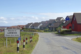 Colourful houses line a street with a welcome sign in a town, Lerwick, Shetland Islands, Scotland,