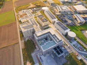 Complex of industrial buildings and fields seen from above in bright sunlight, new hospital