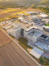 Extensive modern building surrounded by fields, in rural dusk, new hospital building, Calw health