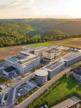 Building complex with modern structures surrounded by fields and trees, new hospital building, Calw