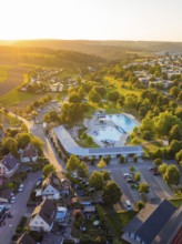 Leisure area with swimming pool and trees in a housing estate at sunset, small town of Perle Calw,