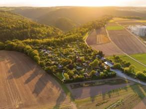 Campsite between forests and fields at sunset with rolling hills, small town Perle Calw, Black