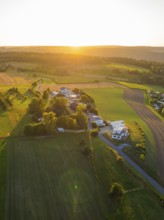Idyllic landscape with fields and buildings in the warm light of the sunset, small town of Perle