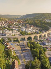 Viaduct running through an urban area over hills and through natural landscape, small town of Perle