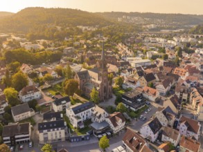 Aerial view of a town with a church in the centre and surrounding historic buildings, small town of