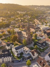 Aerial view of an urban area with a central church in the evening light, small town of Perle