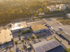 Wide view of an industrial area with car parks and solar panels on the roofs, small town of Perle
