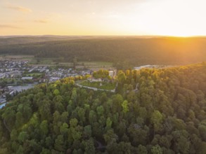 Photo panorama of a castle in dense forests at sunset with a wide view over the landscape, small