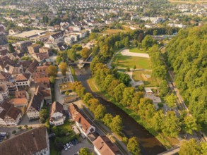 Aerial view of town with river and parkland next to urban development, small town of Perle Nagold,