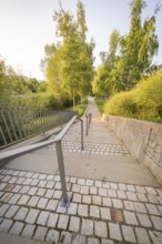 Stone staircase with metal railings, flanked by lush greenery, small town of Perle Nagold, Black