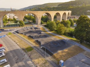 Pump track under a large bridge, surrounded by nature and urban architecture, pump track, Nagold,
