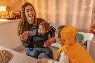 Happy mother and children dressed in festive halloween costumes enjoying fun moments together at