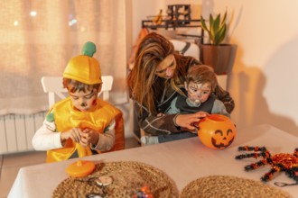 Mother and children wearing festive halloween costumes, joyfully preparing treats together at home,