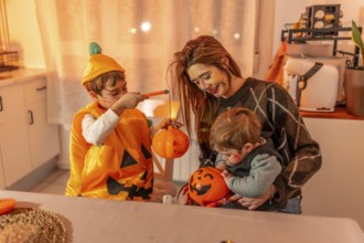 Children and mother painting halloween pumpkins, wearing costumes, and making decorations at home