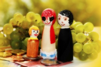 Wooden cone family with grapes and coins and banknotes, alienation, North Rhine-Westphalia, Germany