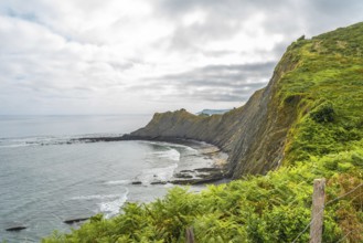 Breathtaking view of the flysch cliffs meeting the ocean waves at sakoneta beach in zumaia, a