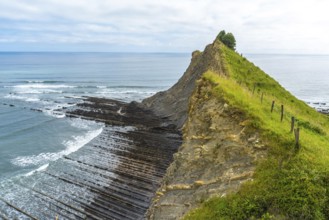 Breathtaking view of the flysch cliffs meeting the ocean waves at sakoneta beach, zumaia, in the