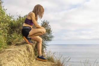 Female athlete taking a break from her training, enjoying the breathtaking scenery of sakoneta