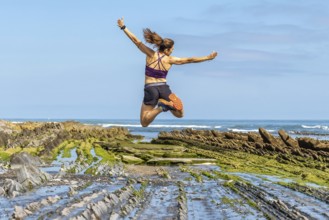 Celebrating freedom and athleticism, a woman leaps with joy amidst the unique geological formations