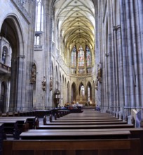 Tourists admiring the stained glass windows and gothic architecture of st. Vitus cathedral in