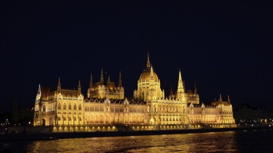 Golden lights highlighting the hungarian parliament building in budapest on the danube river at