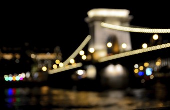 Blurred lights highlighting the chain bridge in budapest, hungary at night, reflecting in the